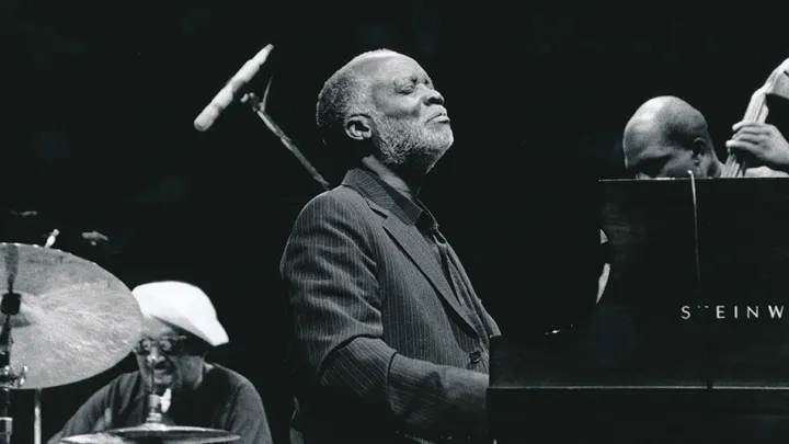 Jazz pianist Ahmad Jamal seated at a grand piano